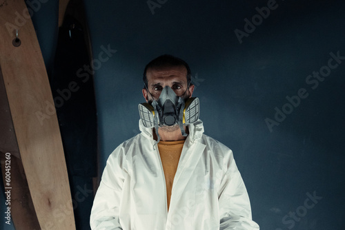 Serious man wearing protective respirator in workshop photo