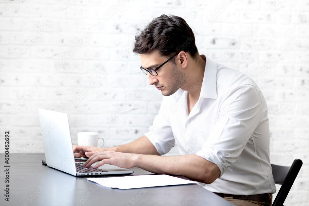 Serious businessman sitting at the table at home and working. Distant work concept Serious businessman sitting at the table at home and working. Distant work concept