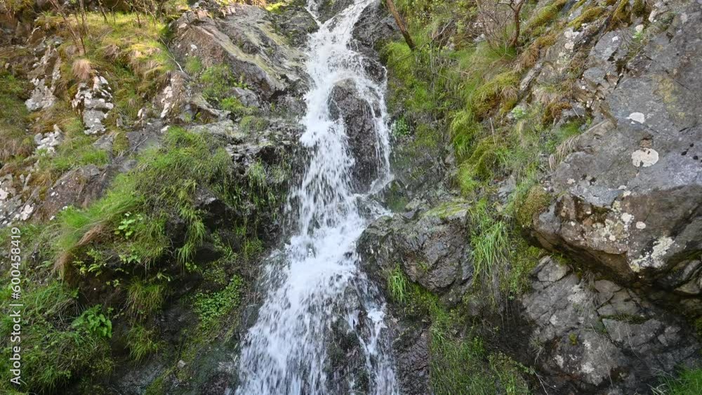 The waterfall that forms after the rainy periods. The water flows on the mountain slope. The waterfall that forms after the rainy periods. The water flows on the mountain slope.