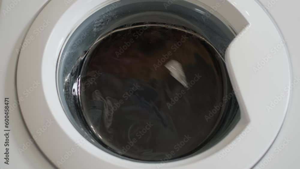 Linen is washed in a washing machine, view through the glass Linen is washed in a washing machine, view through the glass