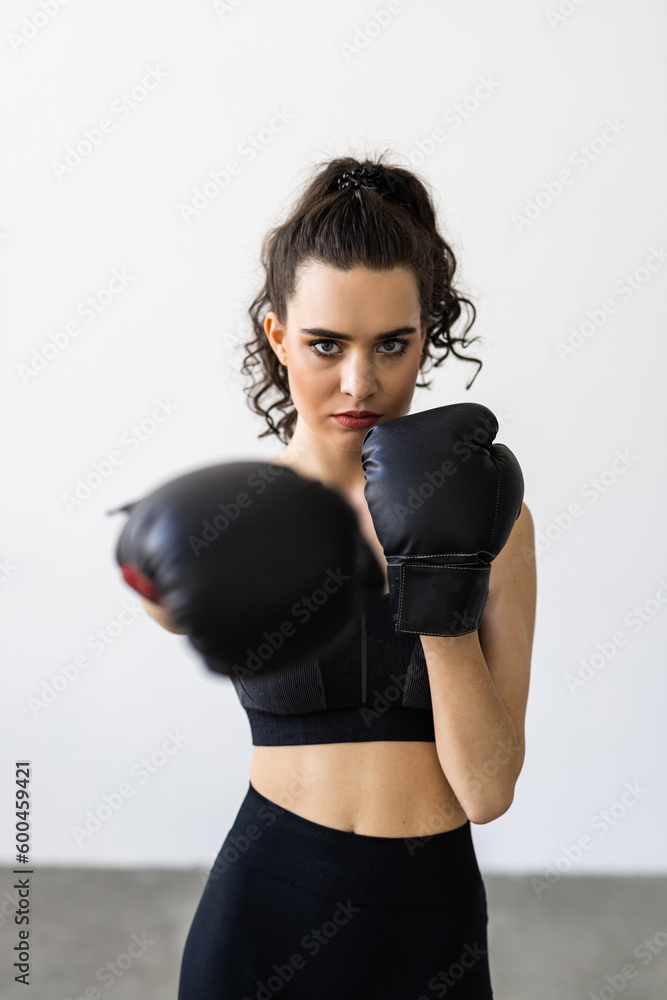 Young woman in boxing gloves standing in the living room