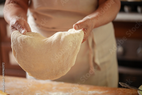 Women's hands make pasty dough