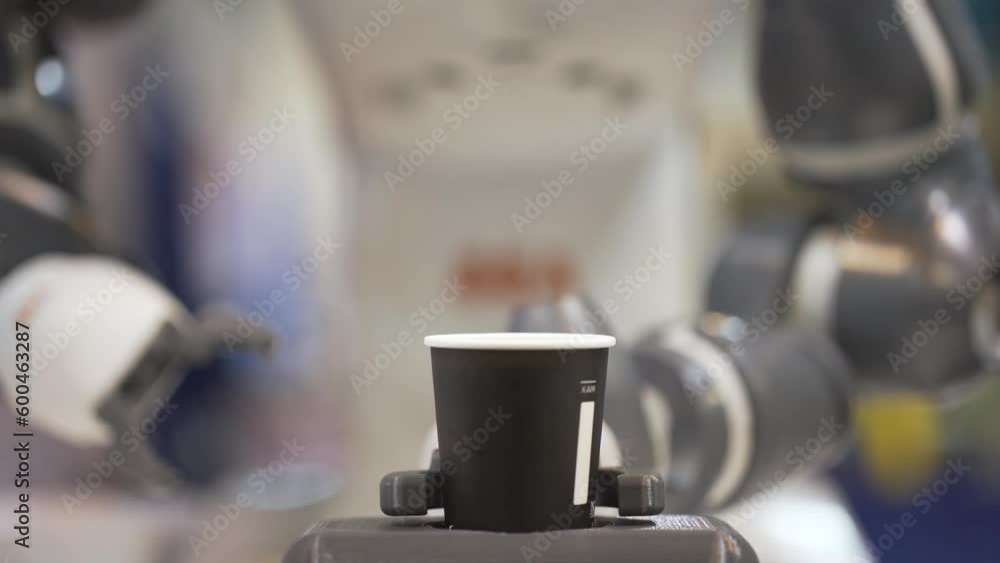 Motion of robotic arm making coffee. Robotic arm takes paper coffee cups. Mechanical robotic arm gives cup of coffee to a customer. Motion of robotic arm making coffee. Robotic arm takes paper coffee cups. Mechanical robotic arm gives cup of coffee to a customer.