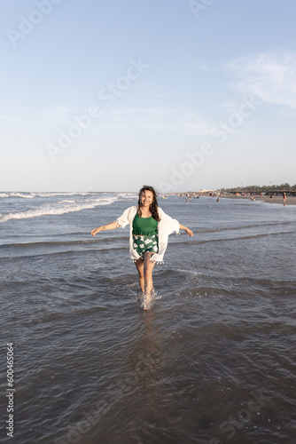 A young Hispanic woman is posing in the sea water at the beach © Miguel Serrano