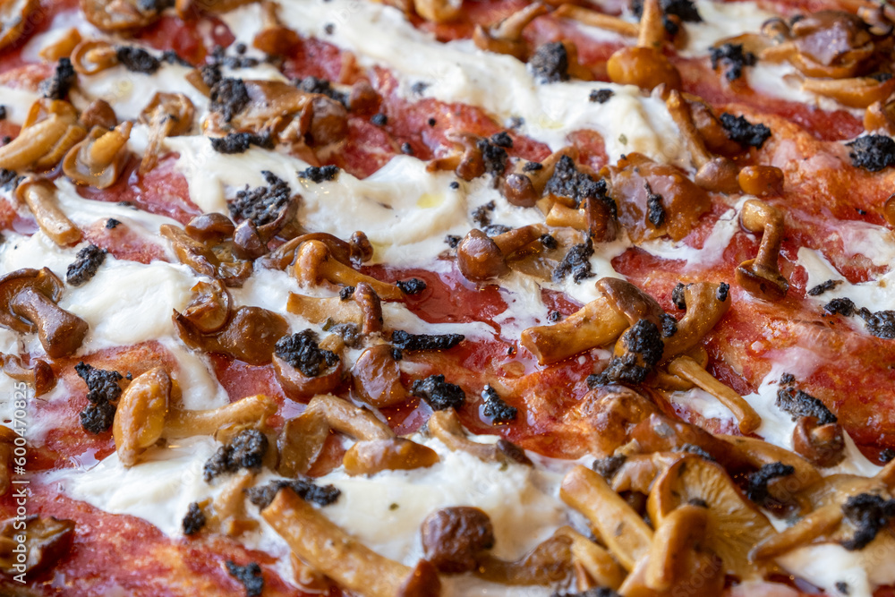 Pizza con pomodoro, mozzarella, crema di olive e funghi, primo piano