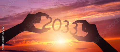2033 - human hands holding black silhouette year number
