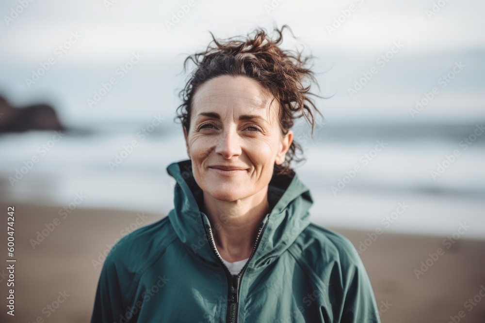 Portrait of smiling middle aged woman looking at camera on the beach
