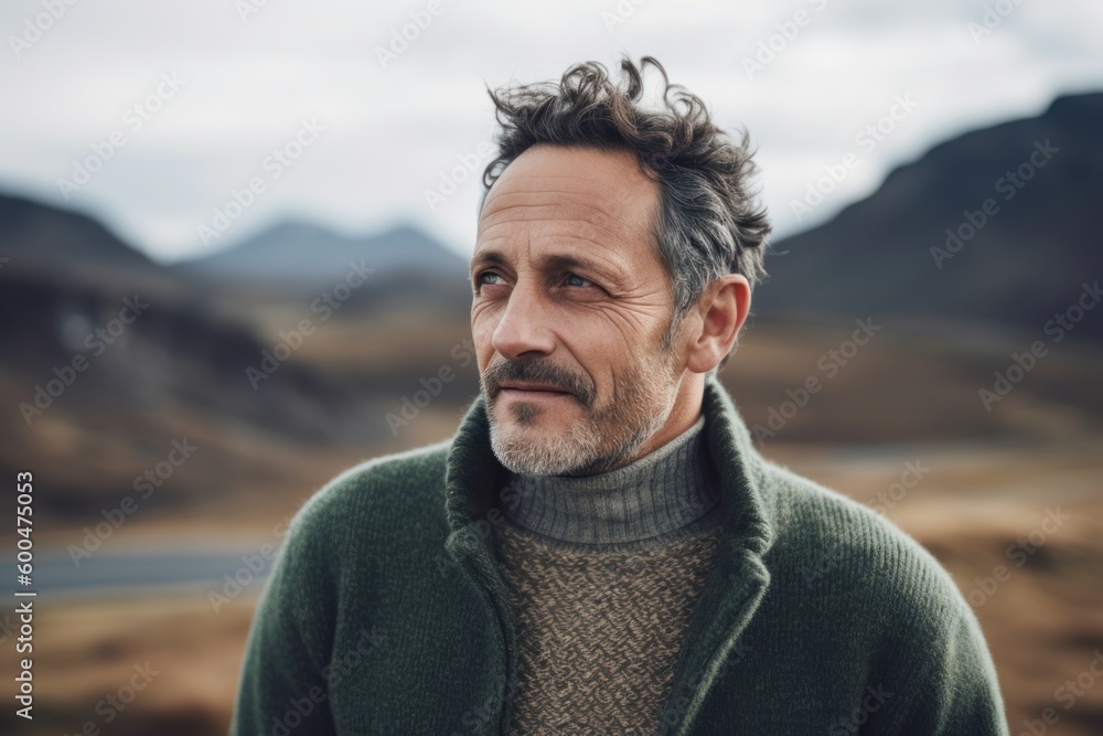 Portrait of a handsome middle-aged man in a green sweater on the background of the mountains. Portrait of a handsome middle-aged man in a green sweater on the background of the mountains.