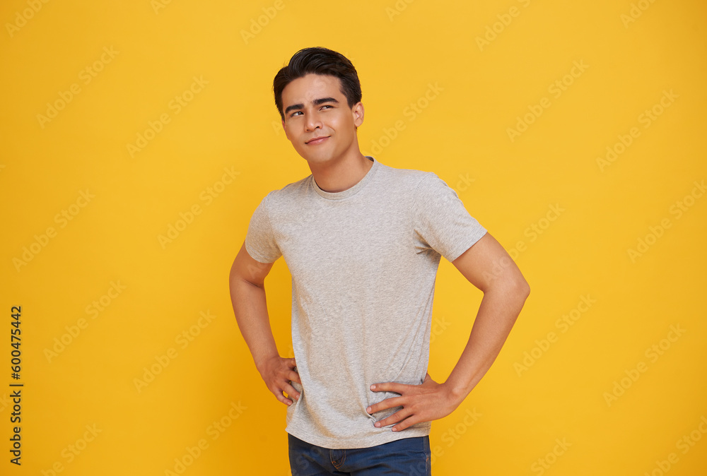 Smart handsome young Asian man thinking while looking up isolated on colorful yellow background. Smart handsome young Asian man thinking while looking up isolated on colorful yellow background.