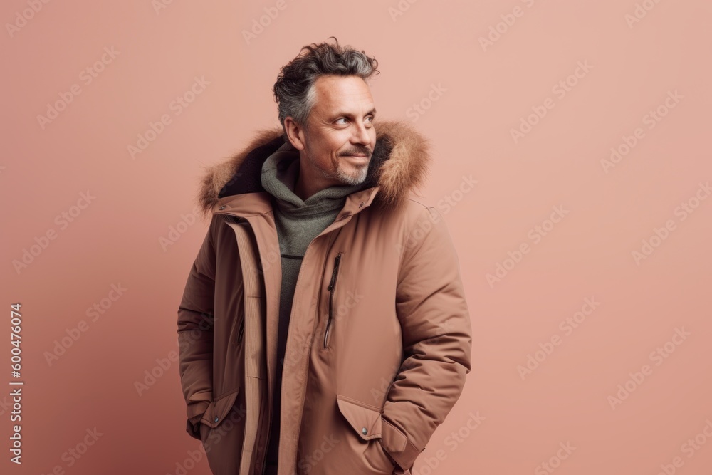 smiling middle aged man in winter coat looking at camera isolated on pink smiling middle aged man in winter coat looking at camera isolated on pink