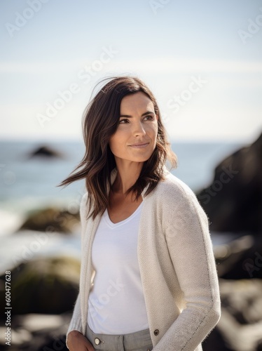 Portrait of a beautiful young woman standing on the beach, looking at camera © Robert MEYNER