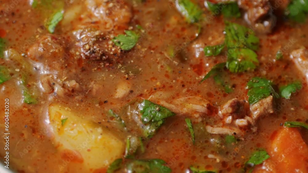 Hungarian goulash soup cooking close-up in pot, chef cook traditional polish or zech soup in restaurant. Hungarian goulash soup cooking close-up in pot, chef cook traditional polish or zech soup in restaurant.