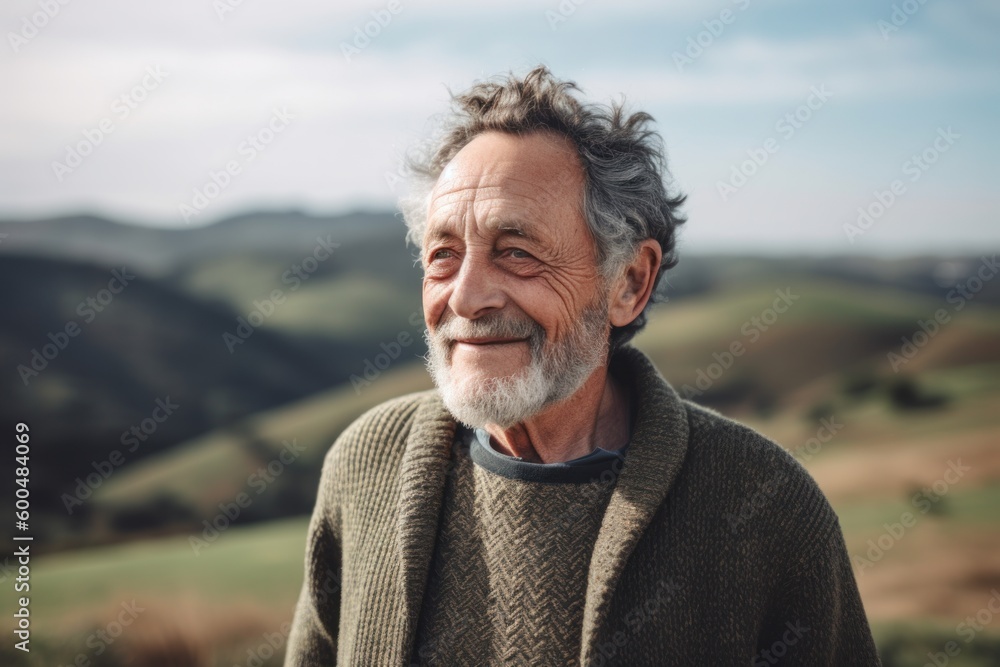 Portrait of happy senior man looking at camera while standing on hillside Portrait of happy senior man looking at camera while standing on hillside