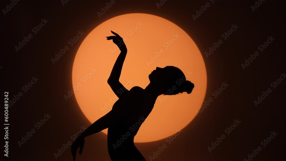 Silhouette of a gracefully dancing woman against the background of a circle of light. Frame up strip Silhouette of a gracefully dancing woman against the background of a circle of light. Frame up strip
