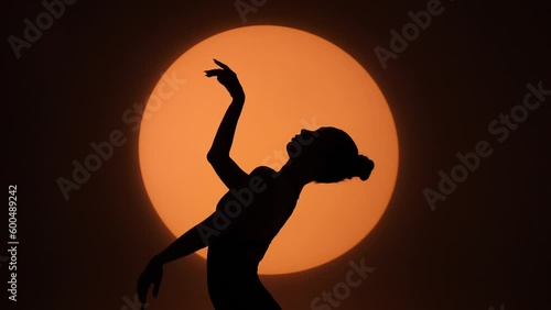 Silhouette of a gracefully dancing woman against the background of a circle of light. Frame up strip