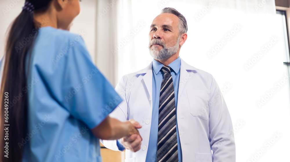 Surgeon medical and doctor people handshaking. Caucasian male doctor shaking hands with team on business cooperation agreement. healthcare and medicine Surgeon medical and doctor people handshaking. Caucasian male doctor shaking hands with team on business cooperation agreement. healthcare and medicine
