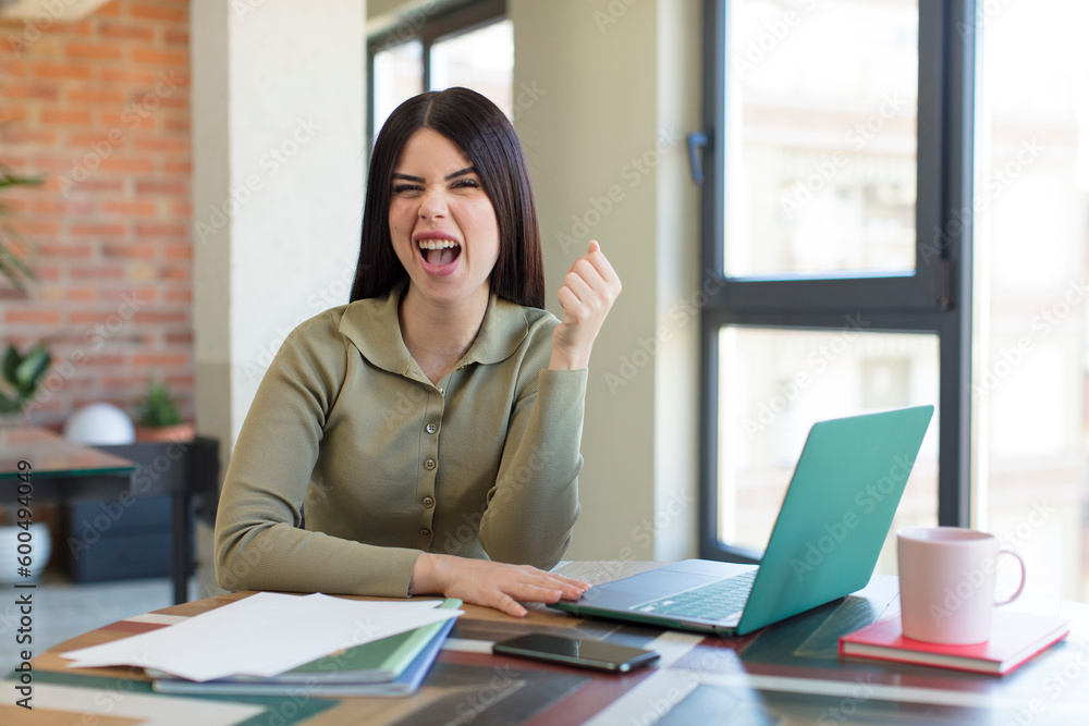 Fototapeta premium pretty young woman looking angry, annoyed and frustrated. laptop and desk concept