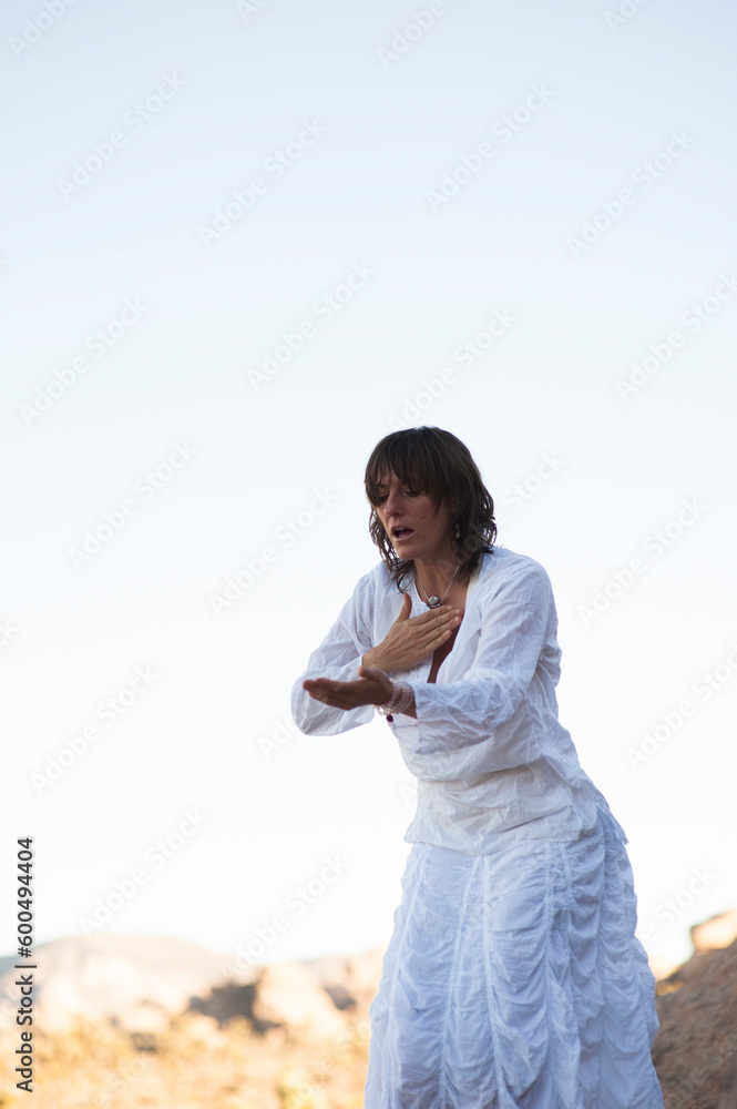 Spiritual woman meditating and chanting in the desert of Joshua Tree. Spiritual woman meditating and chanting in the desert of Joshua Tree.