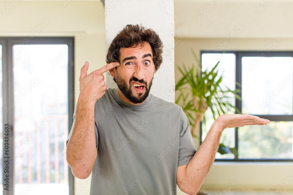 young adult crazy man with expressive pose at a modern house interior young adult crazy man with expressive pose at a modern house interior