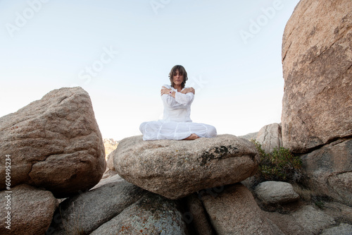 Spiritual woman meditating and chanting in the desert of Joshua Tree. 