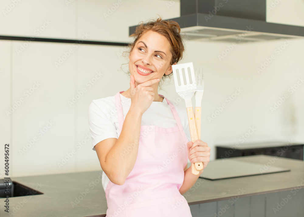 young pretty woman smiling with a happy, confident expression with hand on chin. home chef concept young pretty woman smiling with a happy, confident expression with hand on chin. home chef concept