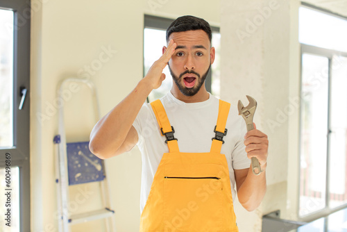 arab handsome man arab man looking happy, astonished and surprised. handyman with a wrench