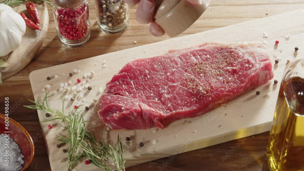 Sprinkling black pepper on beef steak with the mill 03 Sprinkling black pepper on beef steak with the mill 03