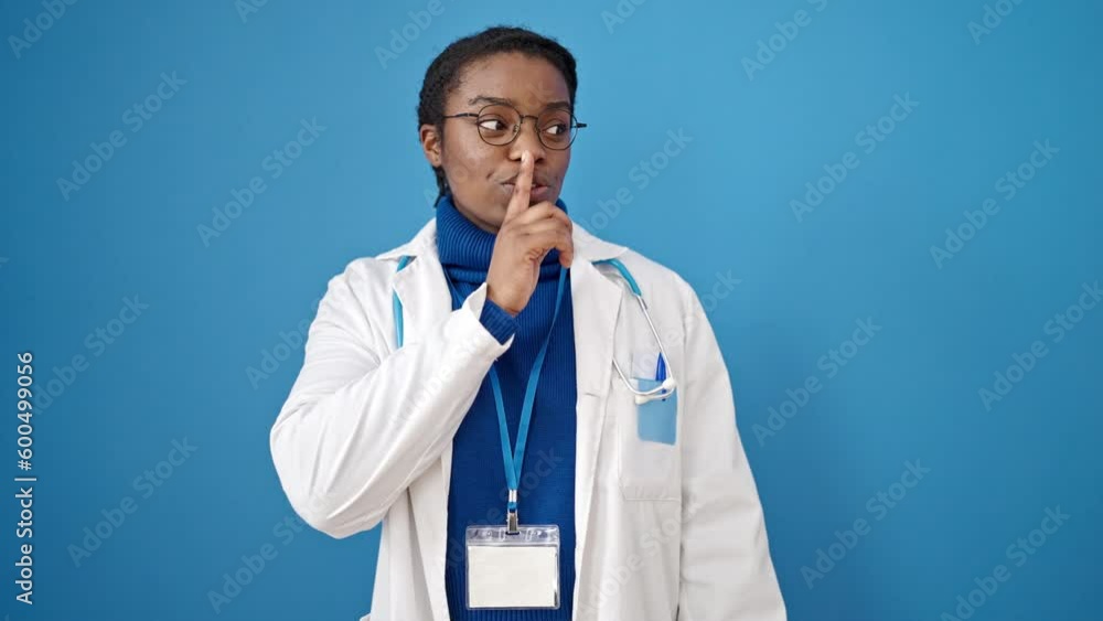 African american woman doctor asking for silent over isolated blue background African american woman doctor asking for silent over isolated blue background