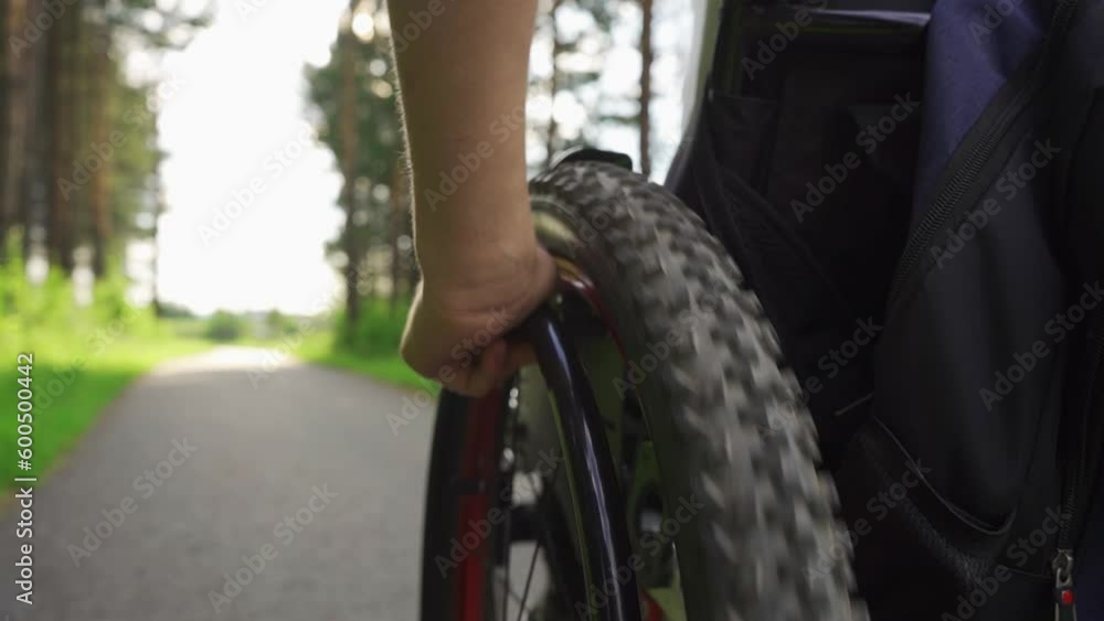 A wheelchair user drives through the park. High quality FullHD footage A wheelchair user drives through the park. High quality FullHD footage