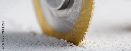 Fotografie Metal saw, end mill or drill bit with diamond coating makes hole in concrete slab
