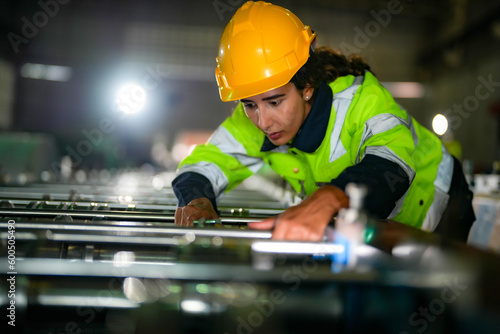 Factory engineer Brazilian woman checking and reparing mahine at heavy factory.Worker works at heavy machine at industry factory. with machinery equipment plant technology. photo