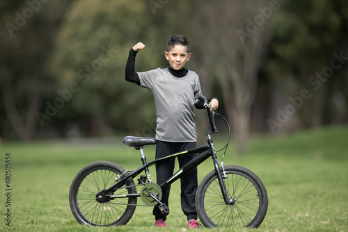 boy posing with his bike in black sweatshirt in the park