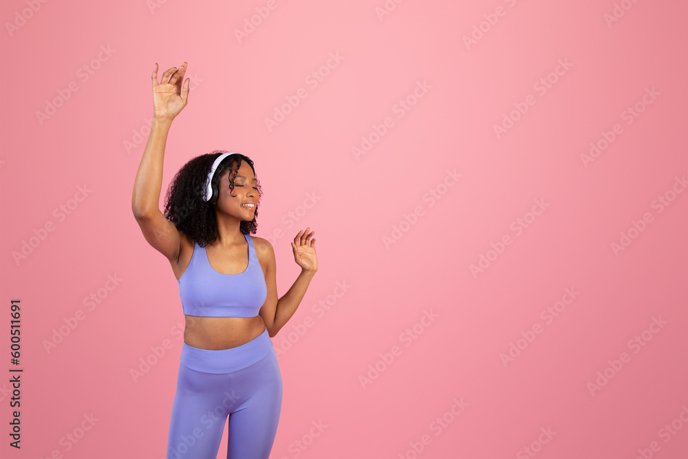 Glad millennial black woman in sportswear, wireless headphones with closed eyes enjoy music Glad millennial black woman in sportswear, wireless headphones with closed eyes enjoy music