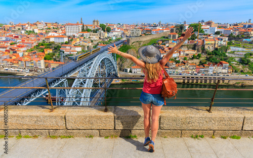 Woman tourist with arms raised enjoying beautiful view of Porto city and famous iron bridge- summer travel destination,  vacation, tourism in Portugal © M.studio