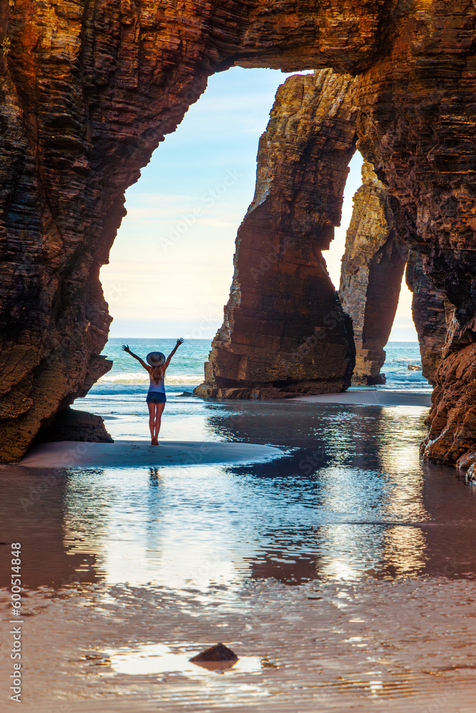 Natural rock arches on Cathedrals beach,  tour tourism in Galicia, Woman, natural arch and beach- Spain - obrazy, fototapety, plakaty 