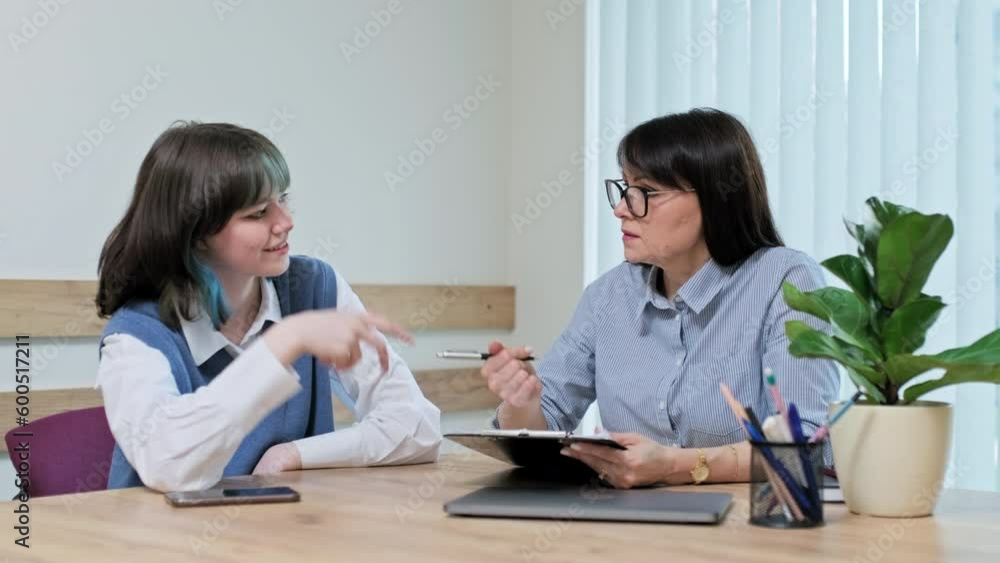 Woman social worker, mentor interviewing, talking to young teen female in office Woman social worker, mentor interviewing, talking to young teen female in office