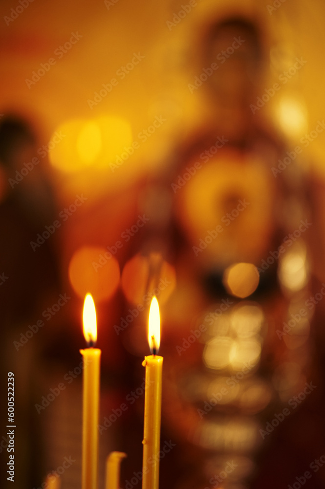 Burning church candles in a gilded candlestick in a temple. Burning church candles in a gilded candlestick in a temple.