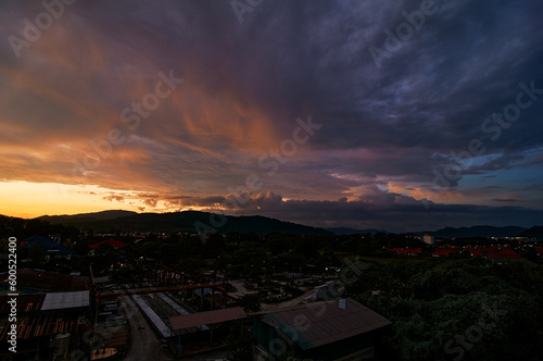 Dramatic landscape with view on evening city. Beautiful cloudy sky.