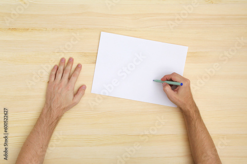 man writing on the paper, top view