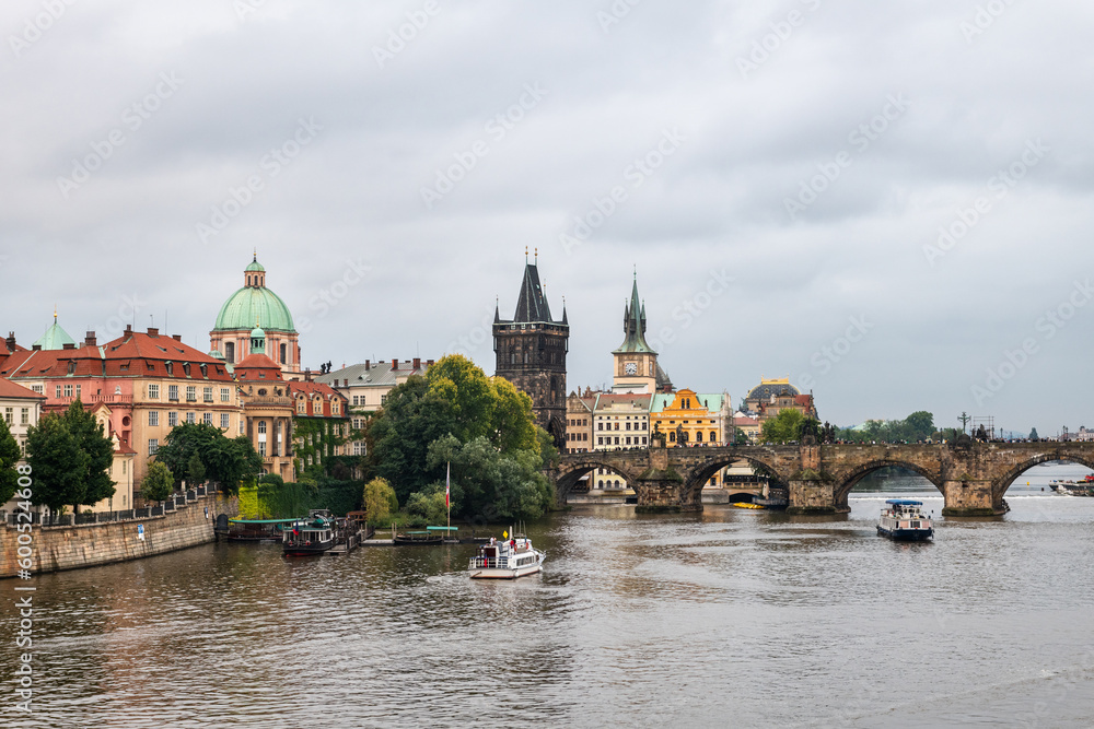 Naklejka premium Wide-angle view of the Vltava river and Charles bridge in Prague on a cloudy afternoon, Czech Republic.