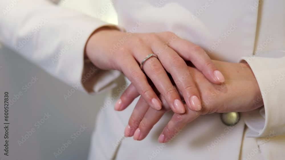 Girl with a pricey and beautiful gold diamond ring places her hand on top of the other in a jewelry store. Engagement ring of the bride to be. Choosing a wedding band at a jewelry store. Girl with a pricey and beautiful gold diamond ring places her hand on top of the other in a jewelry store. Engagement ring of the bride to be. Choosing a wedding band at a jewelry store.