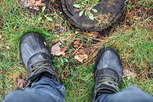 View from above on pair of trekking shoes in a mud.