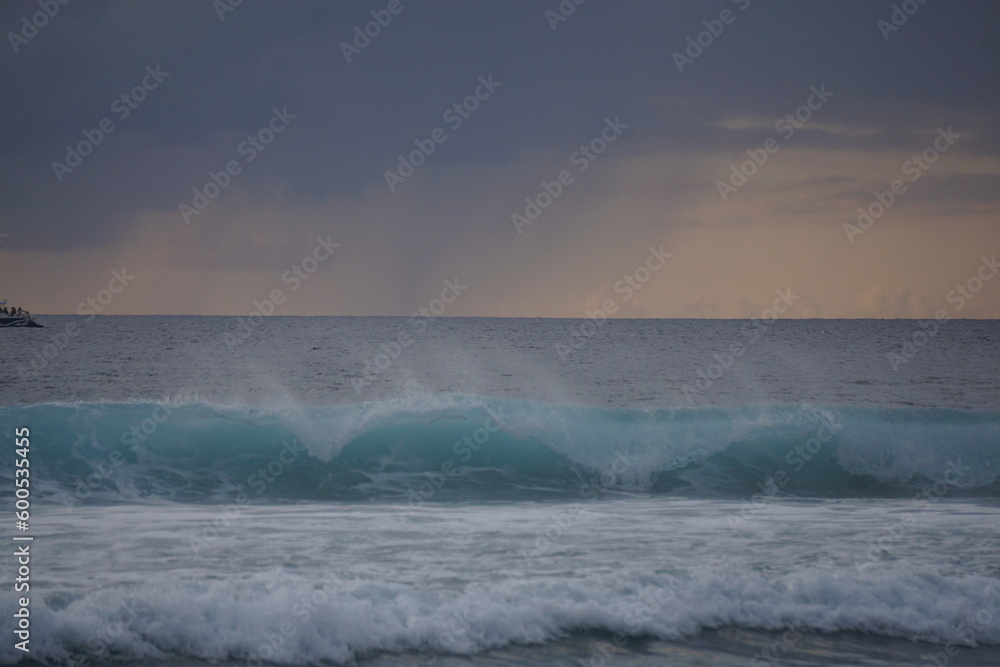 closeup of waves breaking on the beach  on the tropical island of La Réunion, France on a stormy sunset