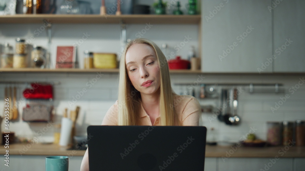 Businesswoman talking video conference at kitchen. Woman working remotely.