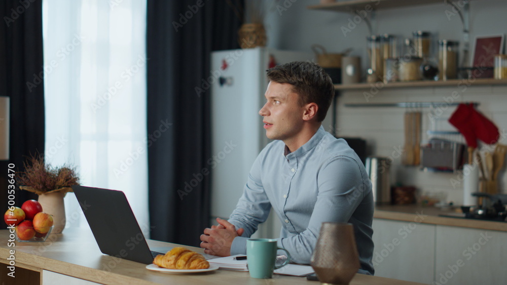 Worker passing online interview using webcam on laptop sitting at kitchen table Worker passing online interview using webcam on laptop sitting at kitchen table