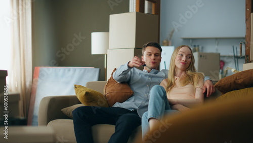 Man giving keys woman from new house. Happy couple sitting on comfortable couch.