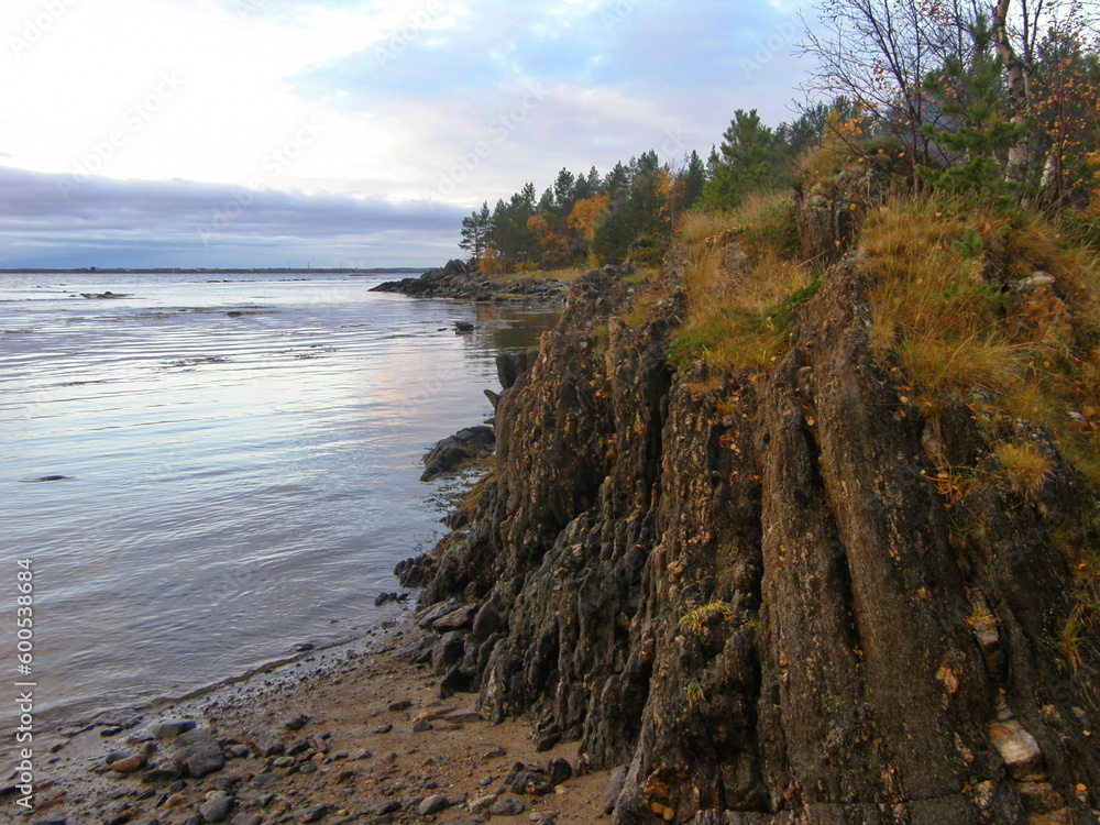 Dark granite stone with thin layers on the shore of the White Sea. Republic of Karelia. Dark granite stone with thin layers on the shore of the White Sea. Republic of Karelia.