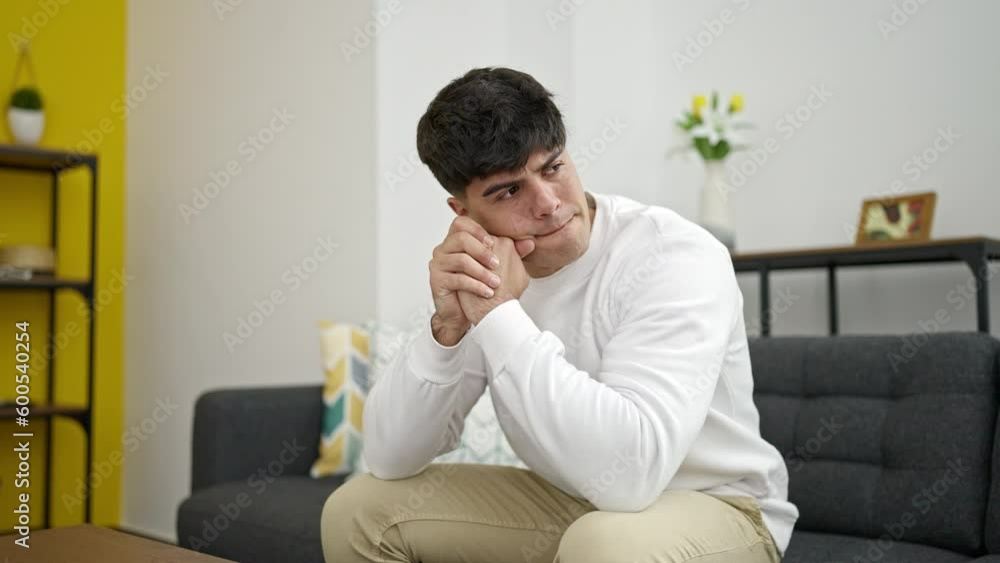Young hispanic man stressed sitting on sofa at home Young hispanic man stressed sitting on sofa at home