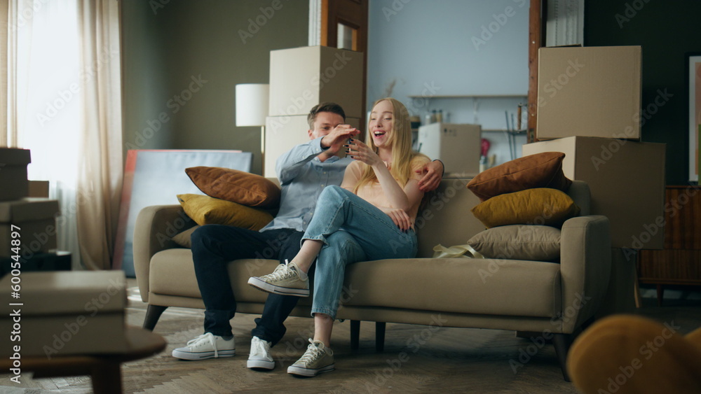 Man gifting keys woman from new home. Happy couple enjoying moving in apartment. Man gifting keys woman from new home. Happy couple enjoying moving in apartment.