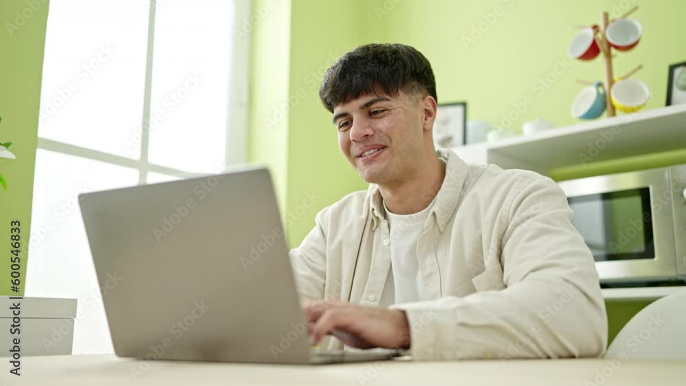 Young hispanic man using laptop sitting on table at dinning room Young hispanic man using laptop sitting on table at dinning room